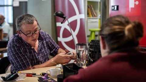un réparateur est en train de réparer un appareil dans un Répair Café